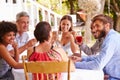 Friends dining together at a table in a garden