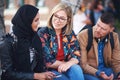 Friends, diversity and happy people with communication and connection outdoor on stairs. Hijab, muslim and talking women