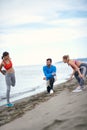 Friends doing stretching exercises on the beach Royalty Free Stock Photo