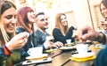 Friends drinking cappuccino at coffee restaurant - Millenial people talking and having fun together at fashion bar cafeteria Royalty Free Stock Photo