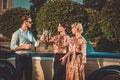 Friends drinking champagne near classic car Royalty Free Stock Photo