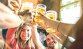 Friends drinking and toasting beer at brewery bar restaurant - Friendship concept on young millenial people having fun together