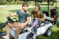 Friends driving golf car Royalty Free Stock Photo