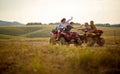 Friends driving quad bikes at the mountains