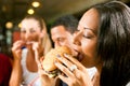 Friends eating fast food in a restaurant Royalty Free Stock Photo