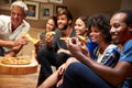 Friends eating pizza at a house party, watching television Royalty Free Stock Photo