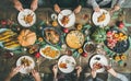 Friends eating at Thanksgiving Day table with turkey and snacks