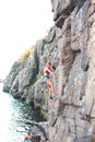 A woman climbs the rock.