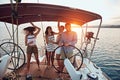 Friends enjoy the vacation on a yacht. Party on a sailboat at sunset Royalty Free Stock Photo