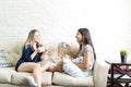 Friends Enjoying Coffee While Conversing On Sofa Royalty Free Stock Photo