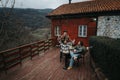 Friends enjoying a cozy musical gathering on a rustic cabin porch. Royalty Free Stock Photo