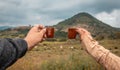 Friends enjoying a drink of mezcal, their hands say cheers in the mezcalero field