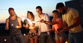 Friends enjoying a rooftop party and dancing with sparklers