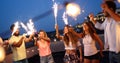 Friends enjoying a rooftop party and dancing with sparklers