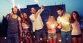 Friends enjoying a rooftop party and dancing with sparklers