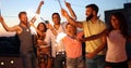 Friends enjoying rooftop party with sparklers Royalty Free Stock Photo