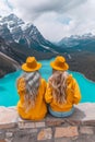 Friends enjoying serene moment by alpine lake with stunning view of majestic mountains