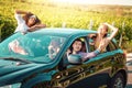 Friends enjoying a summerÃ¢â¬â¢s road trip together countryside. Women and man driving smiling and looking out of window