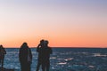 Friends enjoying a sunset by the sea