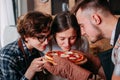 Friends enjoying tasty aroma of delicious hot fresh baked pizza.