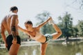 Young friends warm up in the sunny park, exercising outdoors. They stretch, use a rope, and motivate each other