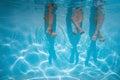 Friends, family legs underwater in the swimming pool with copy space