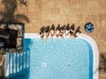 Friends females caucasian people enjoying the swimming pool in summer holiday vacation at hotel or resort - high top vertical view Royalty Free Stock Photo