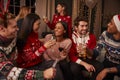 Friends In Festive Jumpers Celebrate At Christmas Party