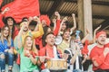 Friends football supporter fans watching soccer match event at stadium - Young people group having fun celebrating