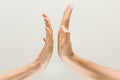 Male and female hands demonstrating a gesture of getting touch isolated on gray background