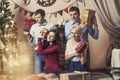 Friends of four men and women give gifts in the Christmas interior Royalty Free Stock Photo