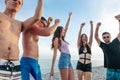 Friends dance on beach under sunset sunlight, having fun, happy, enjoy Royalty Free Stock Photo