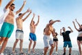 Friends dance on beach under sunset sunlight, having fun, happy, enjoy Royalty Free Stock Photo