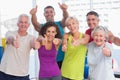 Friends gesturing thumbs up in fitness club