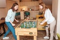 Friends girls take a break and play table football