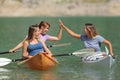 Friends giving five enjoying a kayak day in a lake