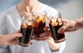 Friends with glasses of cold cola on color background Royalty Free Stock Photo