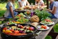 friends grilling vegetables near picnic table with salads and bread Royalty Free Stock Photo