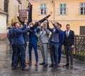 Friends of the groom throw him into the air in front of the church in the Small Square. Sibiu city in Romania