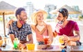 Friends group drinking cocktails at beach with open face masks - New normal vacation concept with people having fun Royalty Free Stock Photo