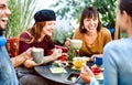 Friends group drinking latte at coffee bar restaurant - Happy people talking and having fun together at hostel dehors Royalty Free Stock Photo