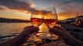 friends hand cheers with wine splash in glass on front sunset beach and sea, bokeh sun flares