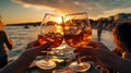 friends hand cheers with wine splash in glass on front sunset beach and sea, bokeh sun flares