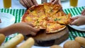 Friends hands taking slices of delicious italian pizza in cafe, good company Royalty Free Stock Photo