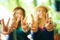 Friends, hands and women with peace sign outdoor at music festival, celebration or event. Closeup, girls and v gesture