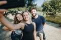 Friends happily socializing in a lush city park on a sunny day, enjoying their carefree weekend.