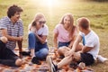 Friends, happiness and leisure concept. Photo of friendly teenagers meet together on nature, have picnic, tell each other funny st