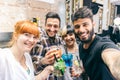 Friends having fun in a bar with cocktails