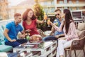 Friends drinking cocktails outdoor on a penthouse balcony Royalty Free Stock Photo