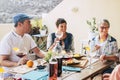 Friends having fun and enjoy together lunch with food and drinks on the table. Mixed ages caucasian people celebrate and enjoy Royalty Free Stock Photo